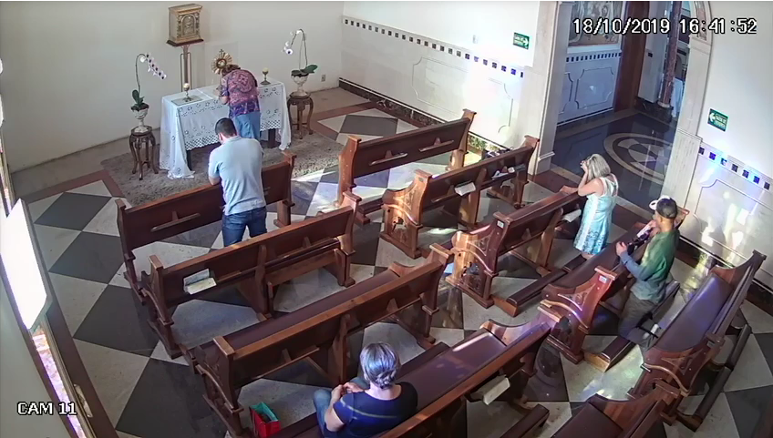 Uma mulher teve o celular furtado enquanto rezava em uma igreja de Goiânia. O crime foi registrado por câmeras de segurança da capela Nossa Senhora Aparecida e Santa Edwiges, no Setor Nova Suíça. (Foto: Reprodução)