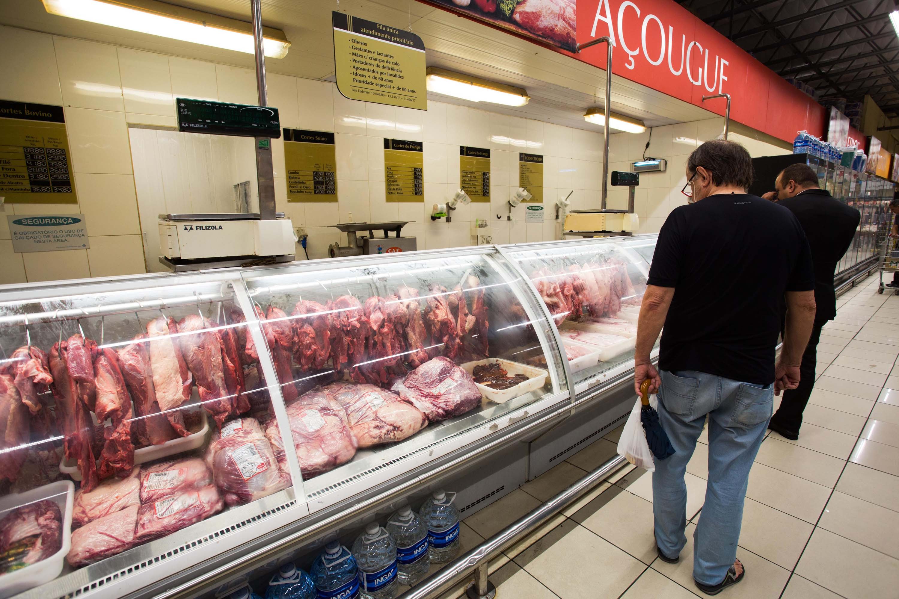 Vista de clientes procurando por carnes em açougue. Preço da carne aumentou no Brasil (Foto: Júnia Garrido/Futura Press/Folhapress)