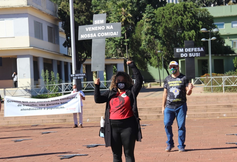 Segurando cruzes e faixas, manifestantes reúnem-se na praça cívica em protesto contra o governo Bolsonaro
