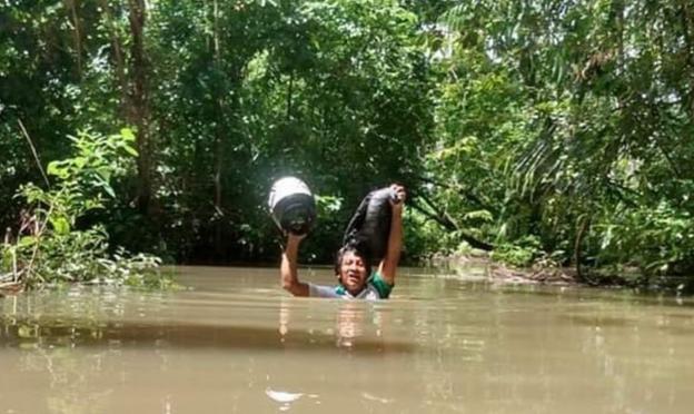 Professor atravessa rio para imprimir atividades de alunos indígenas