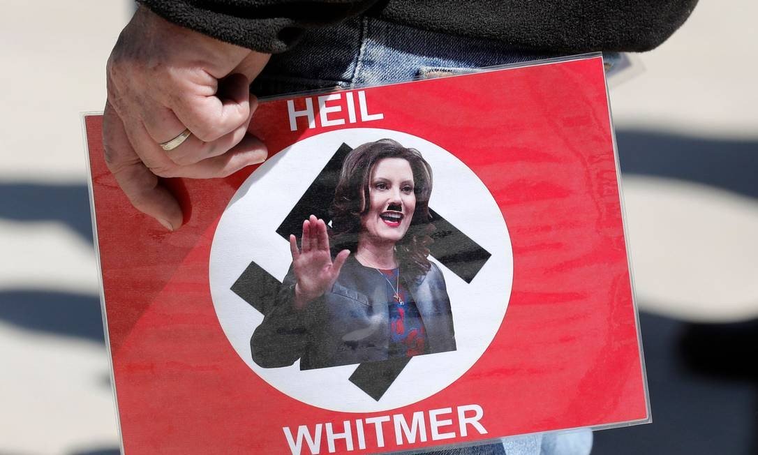 Manifestante carrega cartaz com foto da governadora do Michigan, Gretchen Whitmer, durante evento da Coalizão Conservadora de Michigan, em maio deste ano Foto: JEFF KOWALSKY / AFP