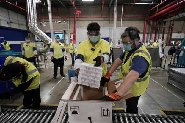 Caixas com a vacina contra covid-19 são preparadas na fábrica da Pfizer, no Michigan (Foto: Morry Gash / Reuters)