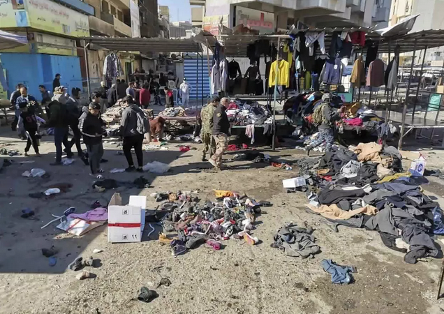 Forças de segurança no local de ataque a bomba em mercado de roupas usadas em Bagdá, capital do Iraque (Foto: Hadi Mizban/AP)