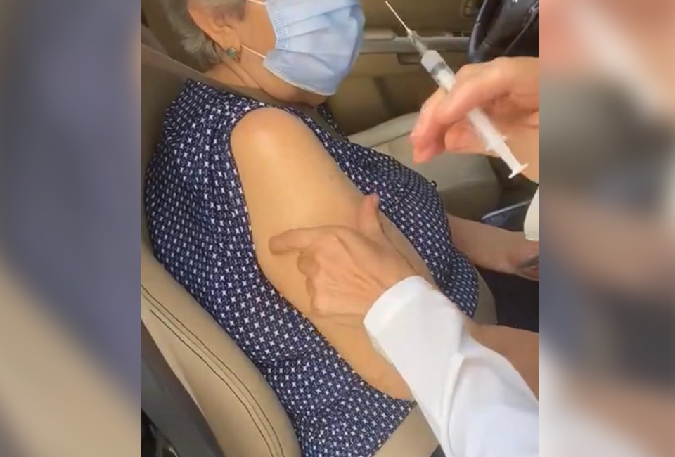 Enfermeira pede que idosa ainda vire o rosto "por causa da agulha" (Foto: reprodução)