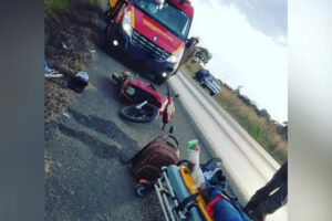 Motociclista perdeu o controle da direção e colidiu contra as rodas traseiras de uma carreta pois a pista estava repleta de óleo.