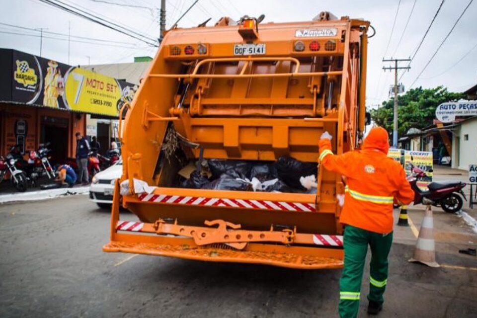 Profissional da prefeitura em caminhão de coleta de lixo