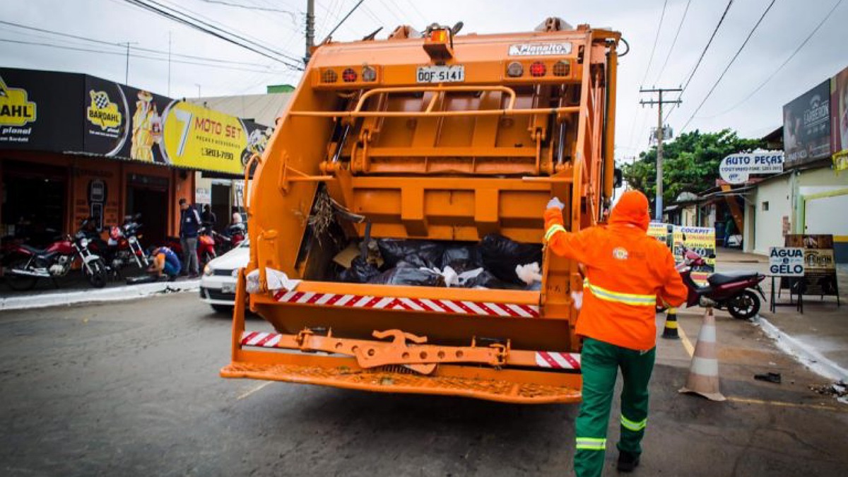 Profissional da prefeitura em caminhão de coleta de lixo