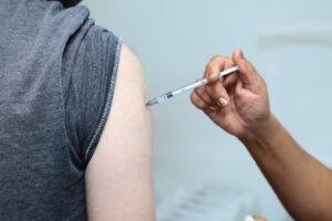 Foto mostra aplicação de vacina em braço de homem em Aparecida de Goiânia