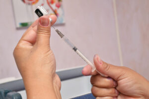 Foto de agulha e ampola de vacina contra Covid-19