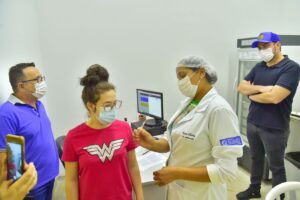 Enfermeira aplica vacina contra Covid-19 em mulher - comerciantes aprovam exigência de cartão de vacinação para entrada em bares de Aparecida