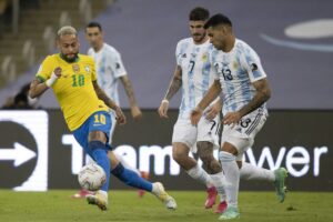 Neymar tenta passar por dois jogadores da Argentina