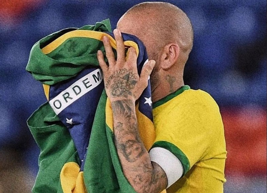 Daniel Alves com a bandeira do Brasil no rosto