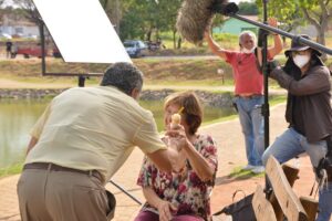 Equipe de filmagem em parque de Aparecida de Goiânia com atriz segurando um sorvete