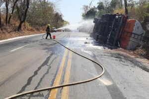 Bombeiro usa mangueira para jogar água em caminhão tombado em Uruaçu