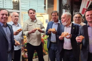 Bolsonaro come pizza em pé em rua dos EUA para evitar exigência de vacina em restaurantes