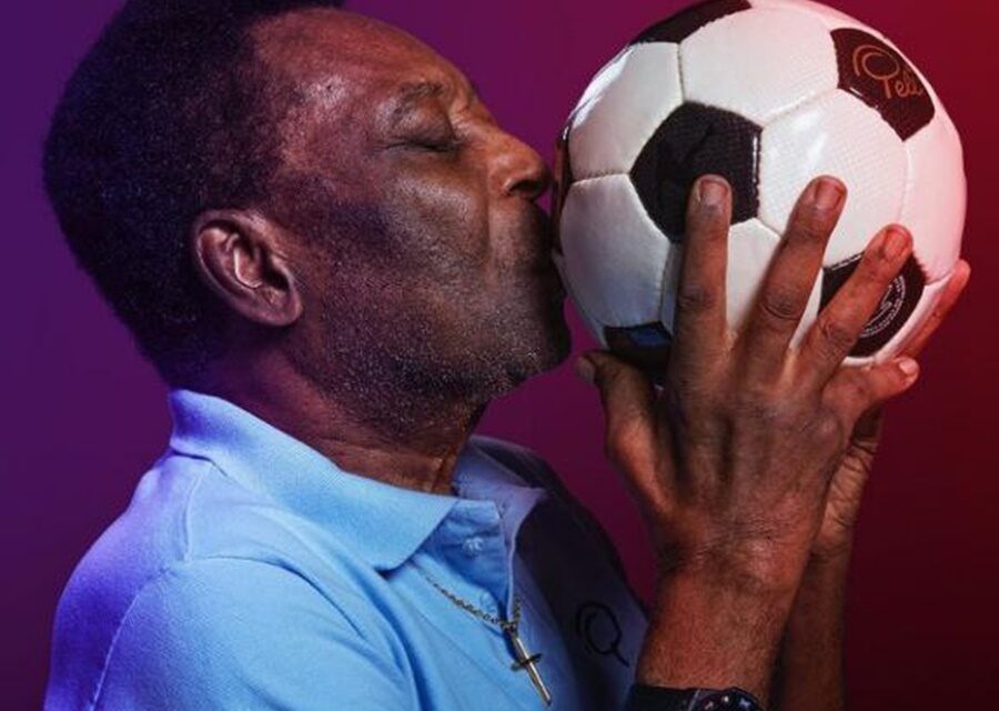 Pelé dá um beijo em uma bola de futebol