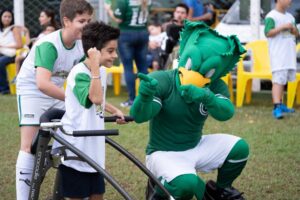 Mascote do Goiás brica com criança em campo de futebol
