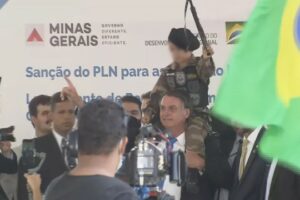 Bolsonaro posa para fotos com criança fardada e com arma de brinquedo na mão, em evento de BH — Foto: TV Globo