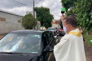 Padre borrifa água benta em "drive-thru" de bênçãos em Goiânia
