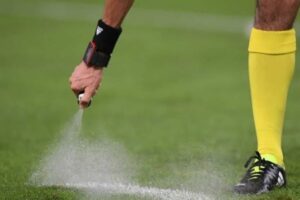 Juiz marca o campo de futebol com spray