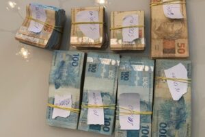 Pacotes de notas de 50 e 100 reais apreendidos pela polícia