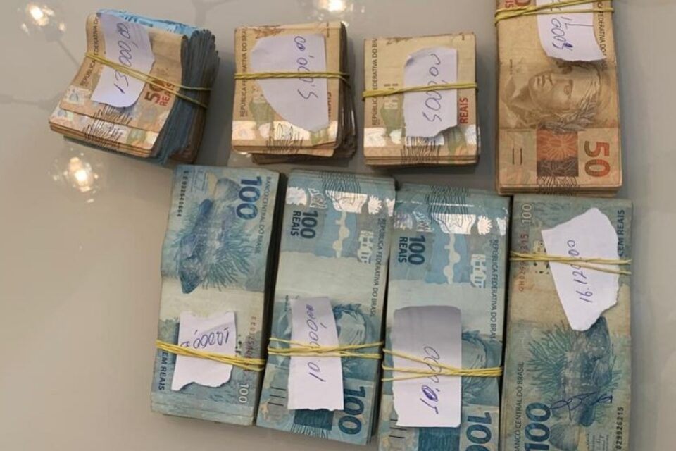 Pacotes de notas de 50 e 100 reais apreendidos pela polícia