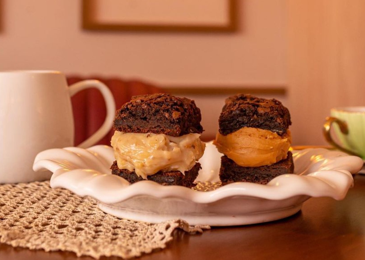 brownies recheados servidos em um prato, ao lado de uma leiteira e xícara de café, da Bem Brownie, opção para comprar brownies em Goiânia 