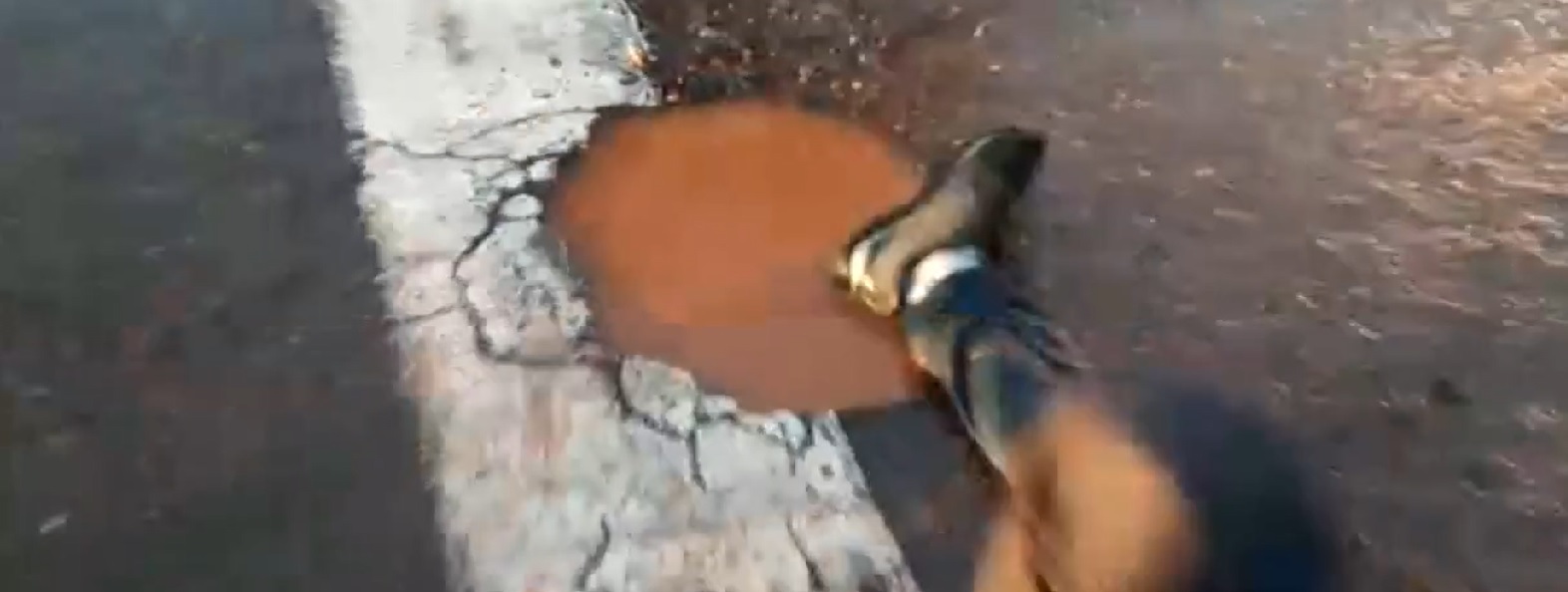 Motociclista estava caído ao lado do buraco, na Avenida Rio Verde (Foto: Reprodução - TVAnhanguera)