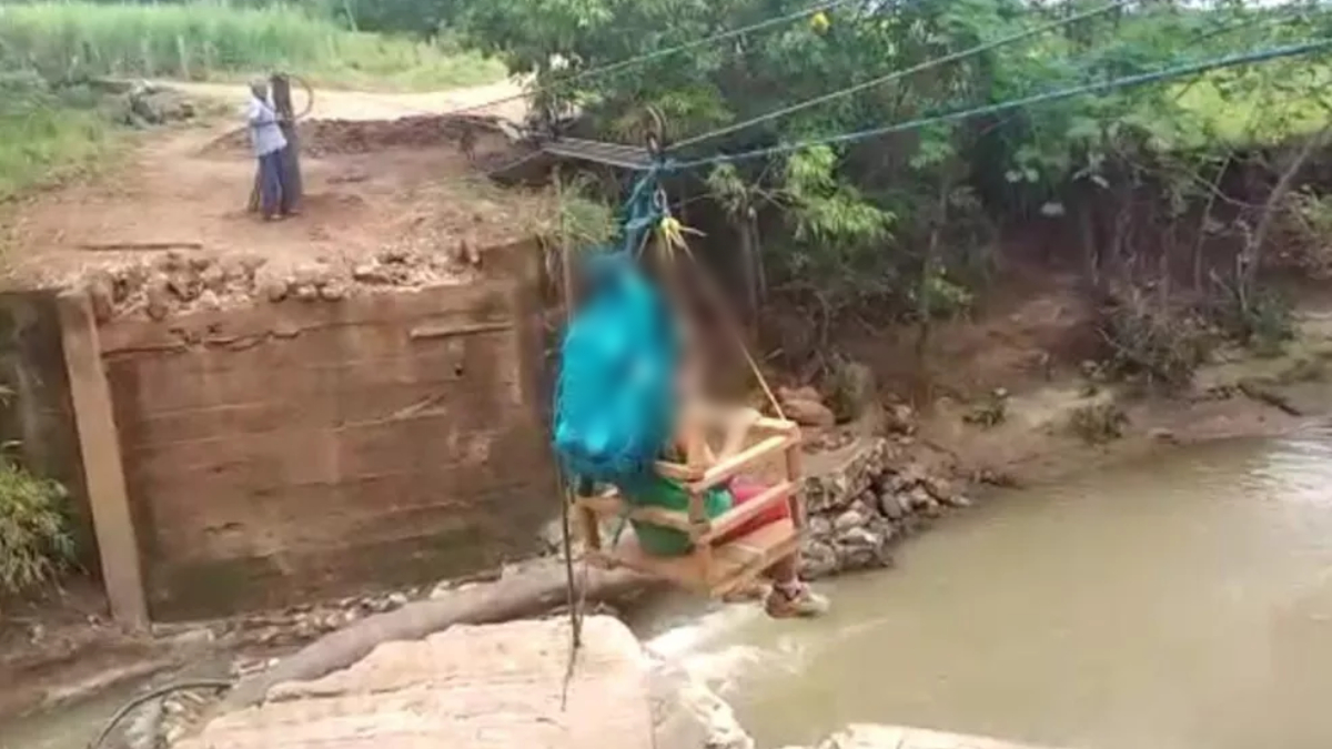 Moradores de Diorama improvisam tirolesa para atravessar sobre córrego após queda de ponte