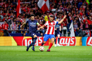 Koke e Gündogan disputam bola no jogo entre Atlético de Madrid e Manchester City