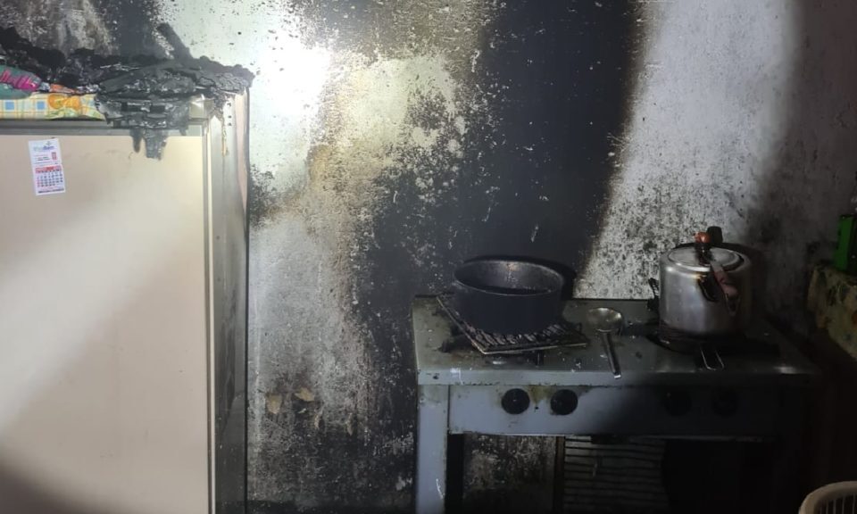 Policiais resgatam mulher de incêndio que começou na cozinha de casa, em Catalão (Foto: Bombeiros)